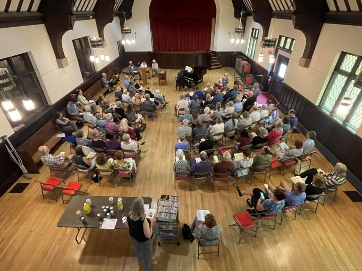 A pianist plays to a crowded service in the Parish Hall.