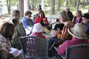 Campers cluster on the porch at the 2023 Sandy Island retreat